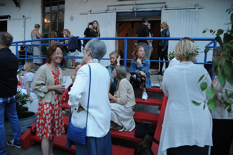 Menschen sitzen auf einer Roten Treppe auf einer Veranstaltung